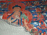 Lo Manthang Thubchen 03-1 Entrance Left Wall Painting Of Buddha Tourists walk quickly past the four Guardian Kings to the main assembly hall in the Thubchen gompa, without stopping to notice that the paintings on the left wall and above and around the assembly hall entrance door are as beautiful as anything inside. A painting of Buddha with his hands in the teaching mudra is on the left wall before the assembly hall entrance.
